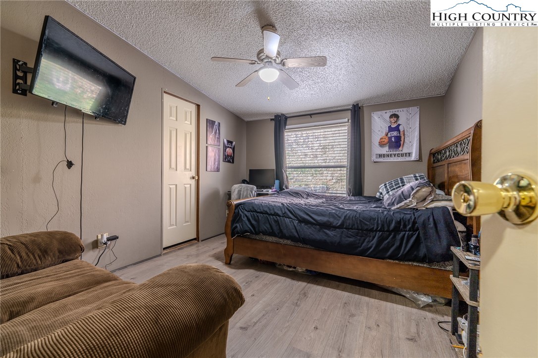672 Upper Hanging Rock Road Spruce Pine, NC 28777 - Photo 15 of 22 a bedroom with a large bed and a flat screen tv