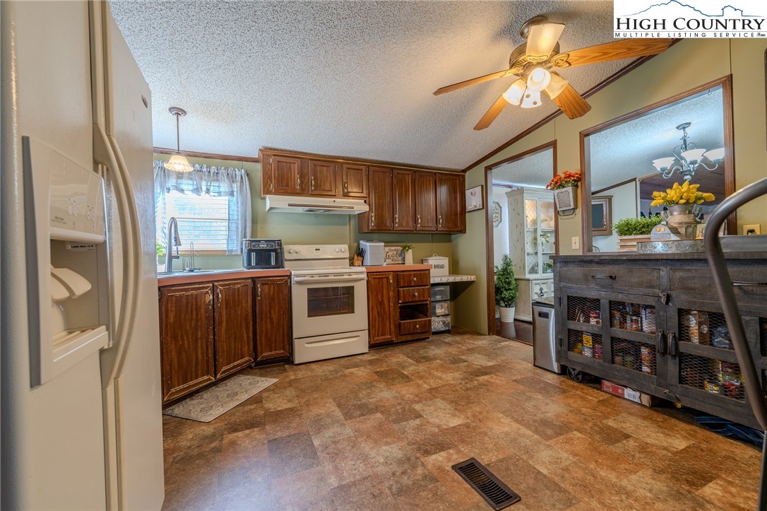 672 Upper Hanging Rock Road Spruce Pine, NC 28777 - Photo 21 of 22 a kitchen with stainless steel appliances granite countertop a refrigerator and a stove top oven