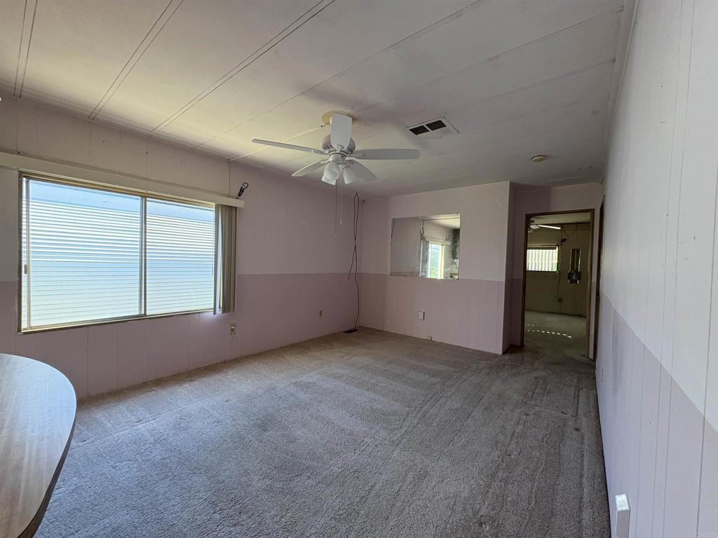 7467 Mission Gorge Road, Unit 293 Santee, CA 92071 - Photo 7 of 49 an empty room with windows and ceiling fan