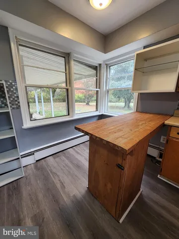 an outdoor space with wooden floor and a window