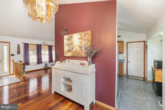 a kitchen with a stove and wooden floor