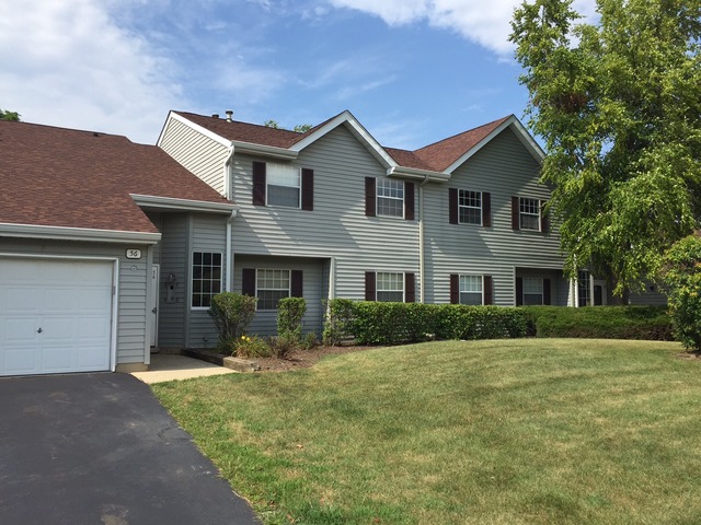 56 North Victoria Lane, Unit B Streamwood, IL 60107 - Photo 1 of 1 a front view of a house with a yard and garage
