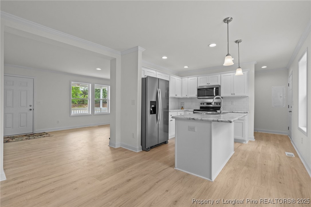1002 Pee Dee Road Aberdeen, NC 28315 - Photo 39 of 46 a kitchen with white cabinets and stainless steel appliances