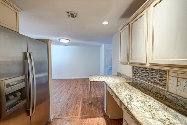 a kitchen with granite countertop a sink and a refrigerator