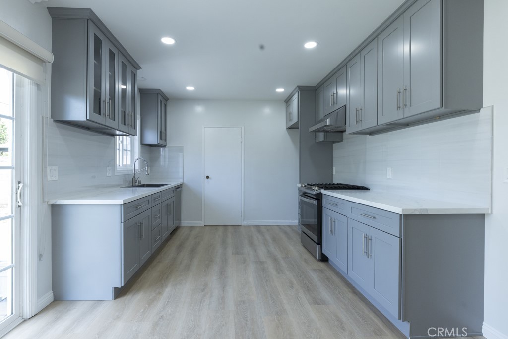 4821 Cathy Avenue Cypress, CA 90630 - Photo 5 of 21 a kitchen with stainless steel appliances granite countertop a sink a refrigerator and wooden cabinets