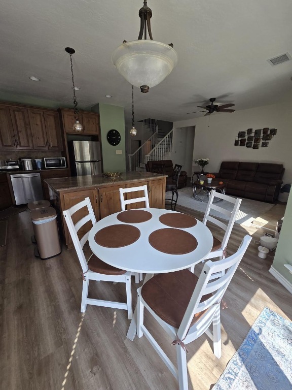 1203 Cardinal Lane Round Rock, TX 78681 - Photo 6 of 17 a dining room with furniture a chandelier and wooden floor