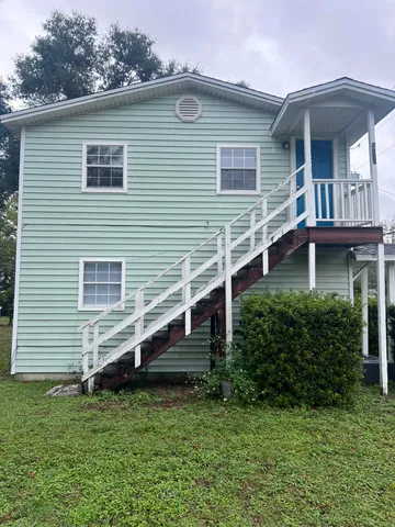 a view of house with a yard and sitting area