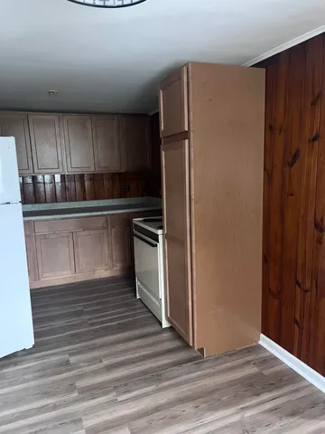 a kitchen with stainless steel appliances a refrigerator and wooden floor