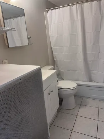 a white toilet sitting next to a white sink and vanity