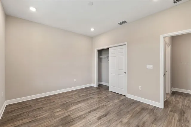 a view of a hallway with wooden floor and a living room