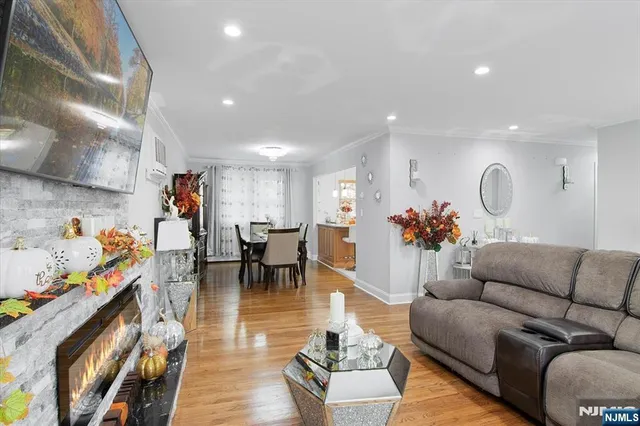 a living room with furniture and a dining table with wooden floor