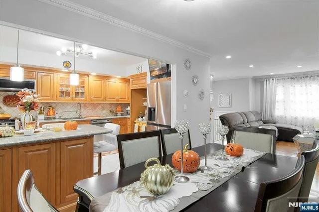 a kitchen with stainless steel appliances granite countertop a table chairs and a dining table