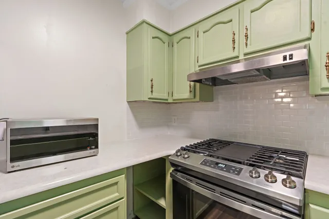 a stove top oven sitting inside of a kitchen