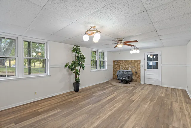 an empty room with windows and fireplace