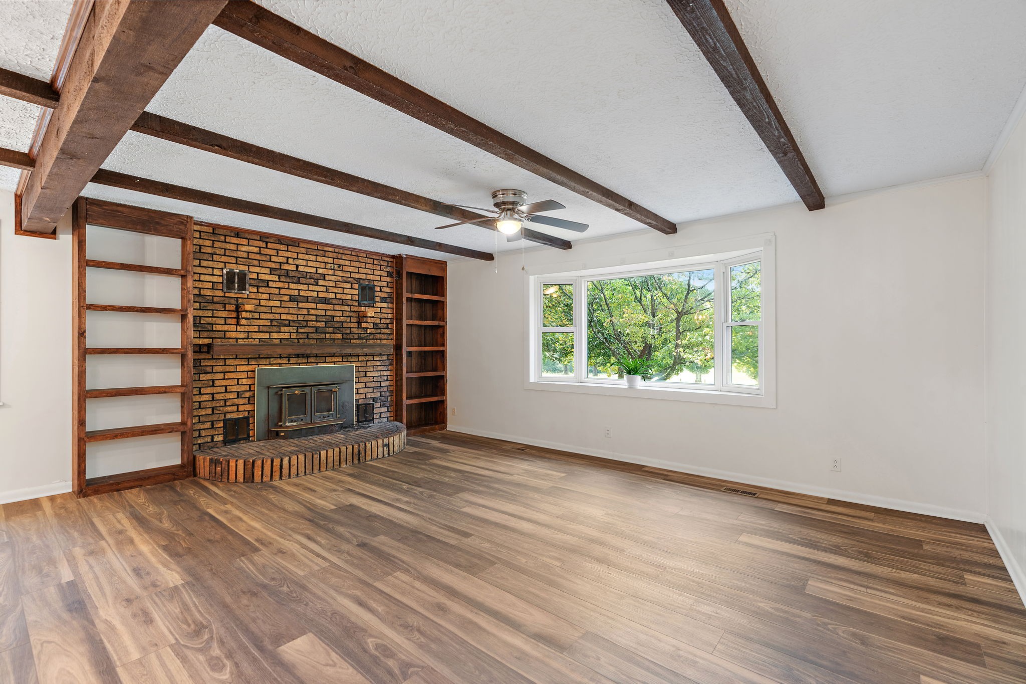 1627 West Grab Creek Road Dickson, TN 37055 - Photo 5 of 46 an empty room with wooden floor fireplace and windows