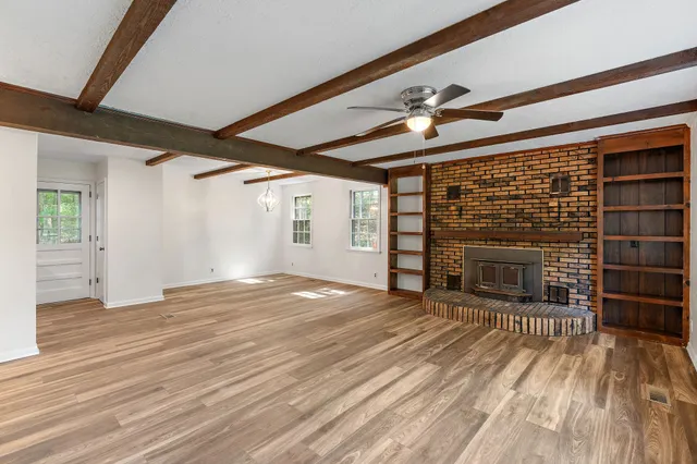 a view of empty room with wooden floor and fireplace