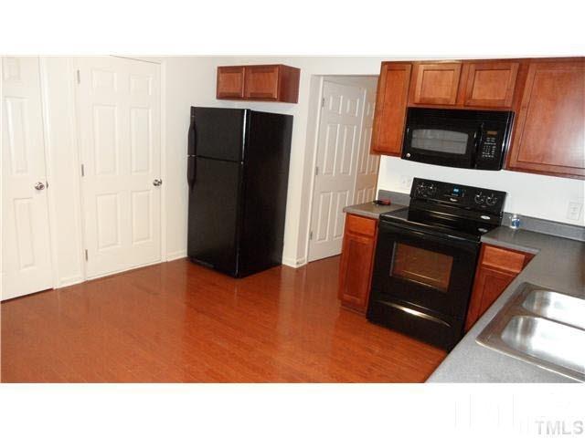 6610 Frogstool Lane Raleigh, NC 27610 - Photo 4 of 11 a kitchen with a refrigerator stove and microwave