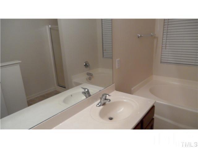 6610 Frogstool Lane Raleigh, NC 27610 - Photo 7 of 11 a bathroom with a sink tub and a mirror