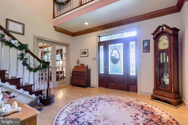a view of front door with entryway and wooden floor