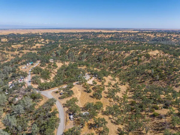 an aerial view of mountain with yard