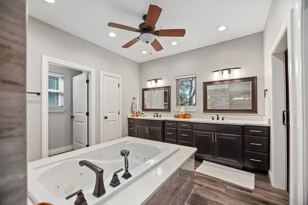a bathroom with a granite countertop shower a mirror and toilet