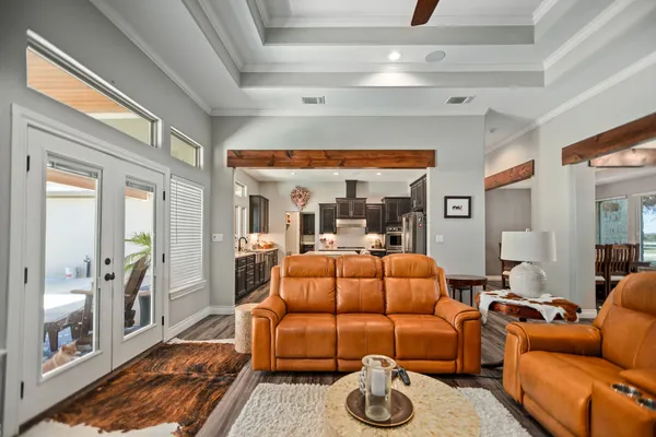 a living room with furniture a flat screen tv and a floor to ceiling window