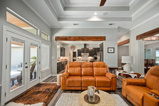 a living room with furniture a flat screen tv and a floor to ceiling window