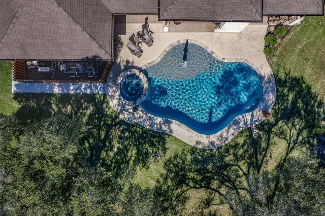 an aerial view of a house with a yard and trees