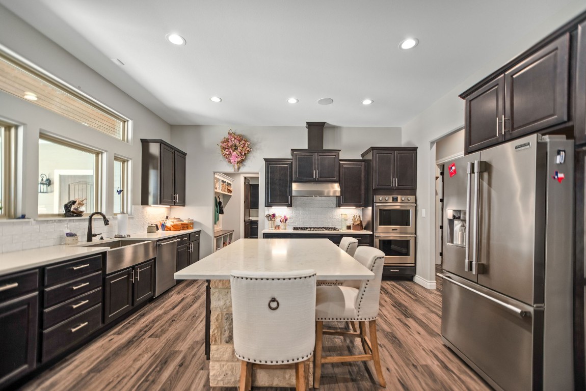 437 Bischoff Road Inez, TX 77968 - Photo 6 of 45 a kitchen with stainless steel appliances granite countertop a refrigerator a sink dishwasher a stove and white cabinets with wooden floor