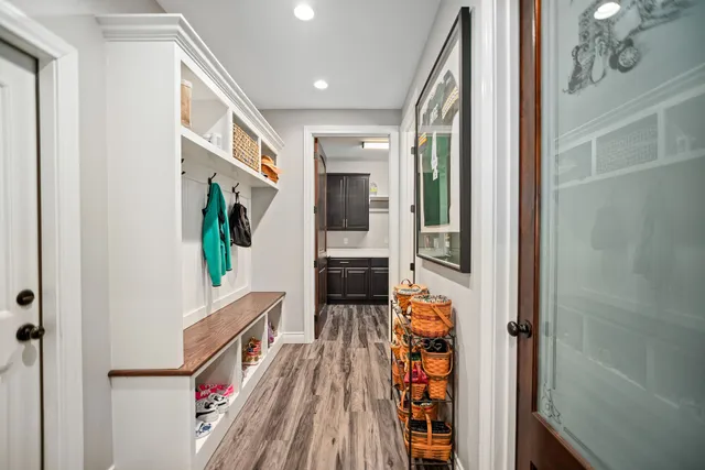 a hallway with wooden floor stairs and furniture