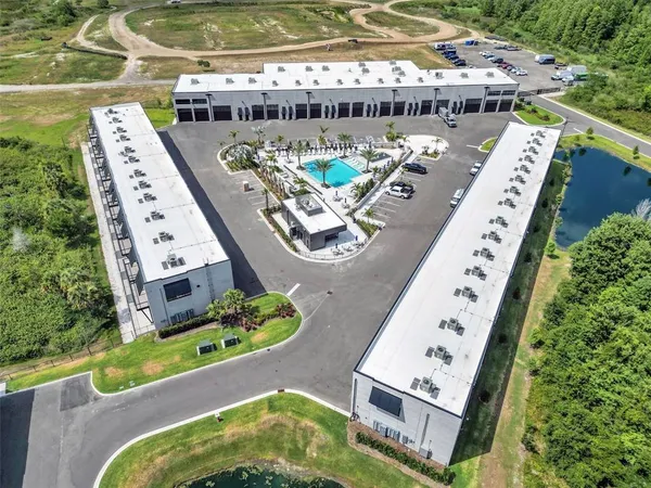 an aerial view of a swimming pool with outdoor seating