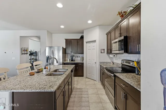 a kitchen with stainless steel appliances granite countertop a refrigerator stove microwave and sink
