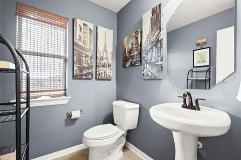 a bathroom with a sink toilet and a mirror