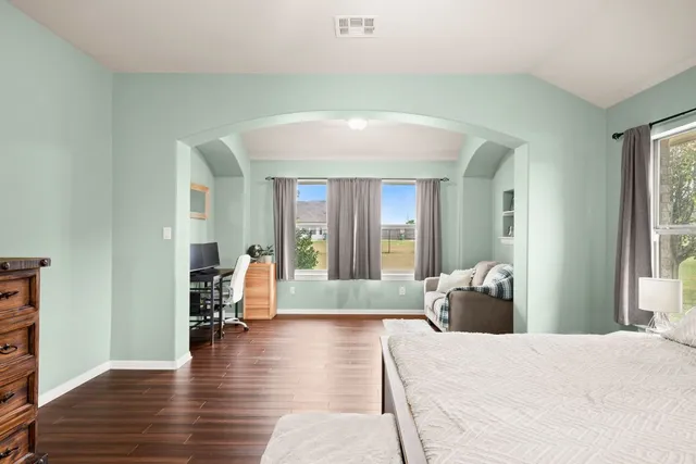a living room with furniture and a wooden floor