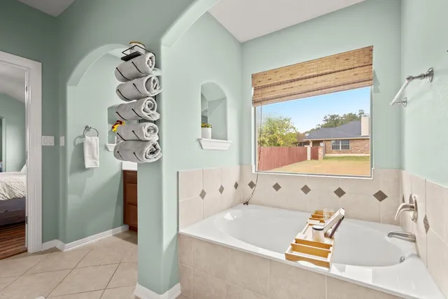 a bathroom with a tub sink and mirror