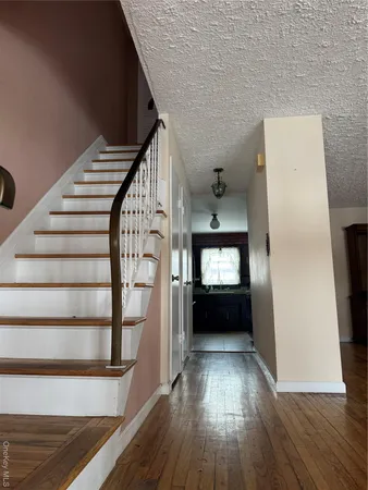 a view of entryway and hall with wooden floor