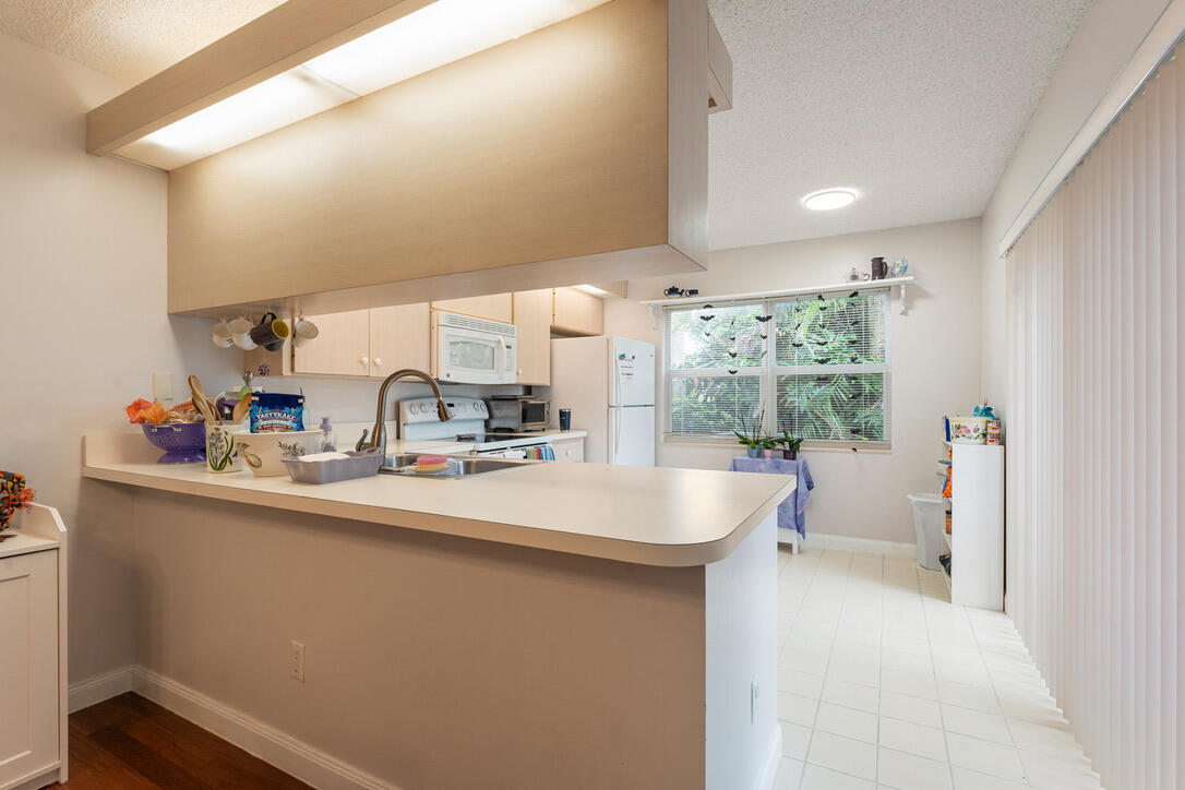 4102 Roxbury Court, Unit 41B Boynton Beach, FL 33436 - Photo 11 of 24 a kitchen with sink cabinets and outdoor view