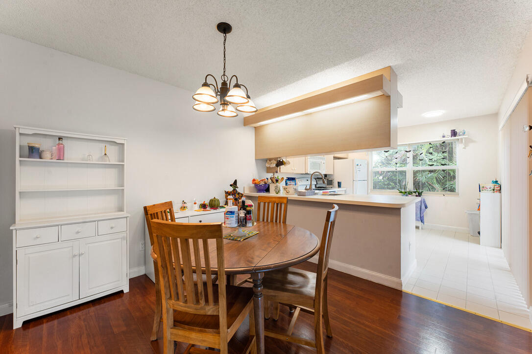 4102 Roxbury Court, Unit 41B Boynton Beach, FL 33436 - Photo 10 of 24 a view of a dining room with furniture wooden floor and chandelier