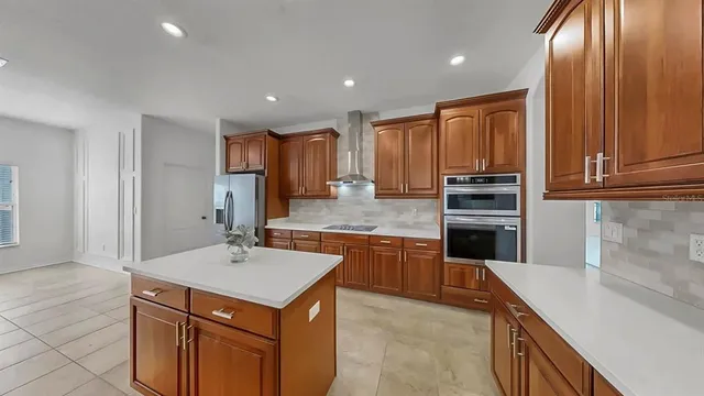 a kitchen with kitchen island granite countertop wooden cabinets and stainless steel appliances