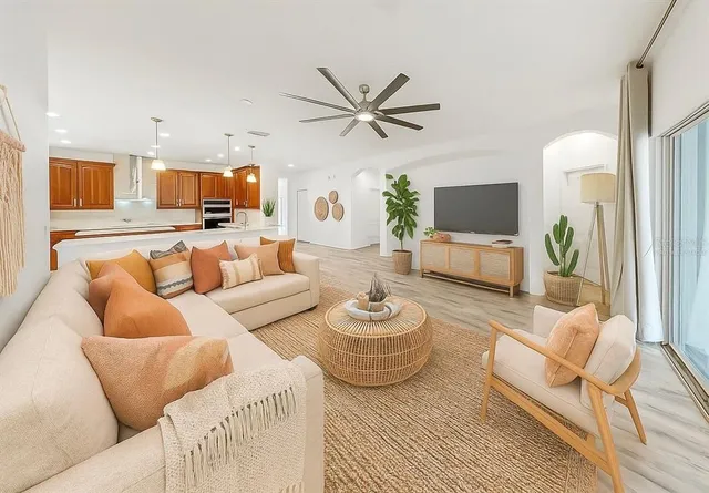 a living room with furniture a flat screen tv and a couch