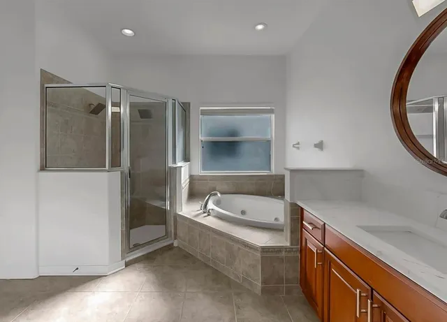 a bathroom with a tub sink and mirror