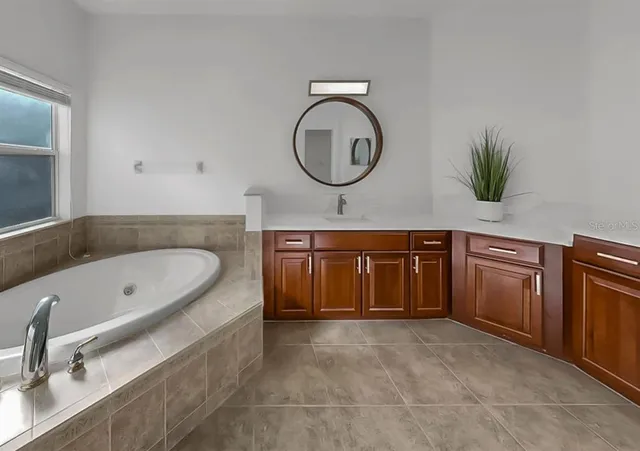 a bathroom with a tub sink and mirror