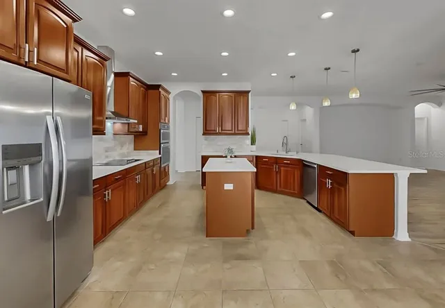 a large kitchen with stainless steel appliances lots of counter top space