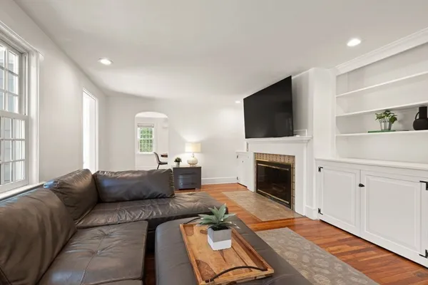 a living room with furniture a flat screen tv and a fireplace