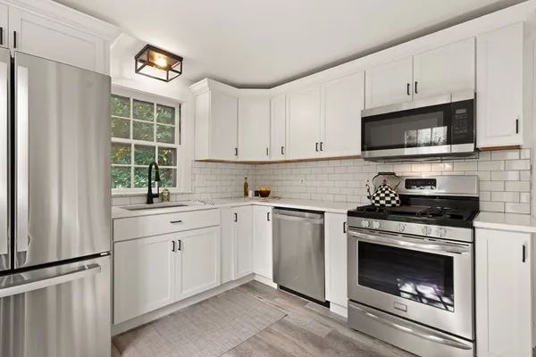 a kitchen with cabinets appliances and a window