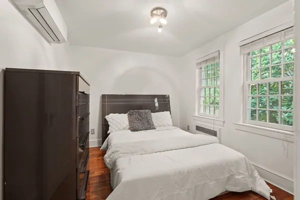 a bedroom with a large bed and wooden floor