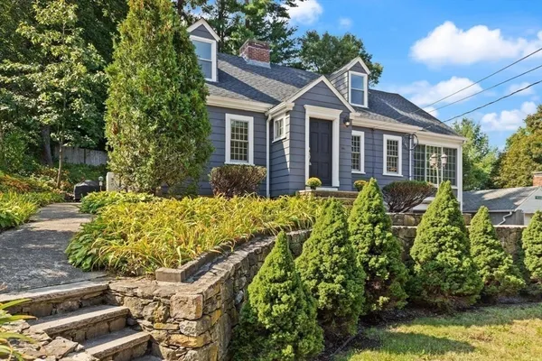 a front view of a house with a yard and potted plants