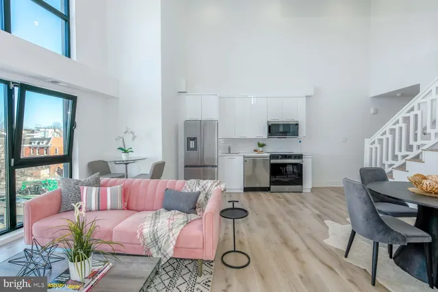 a living room with furniture a fireplace and a kitchen view
