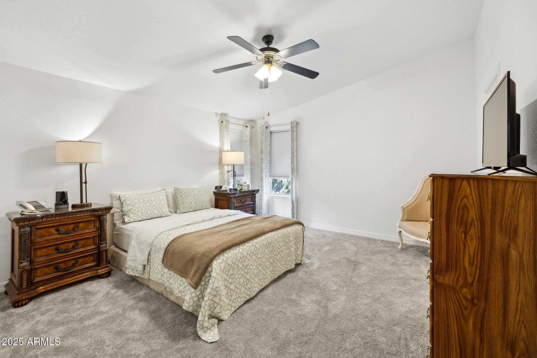 3901 East Pinnacle Peak Road, Unit 105 Phoenix, AZ 85050 - Photo 10 of 23 a bedroom with a bed and a chandelier