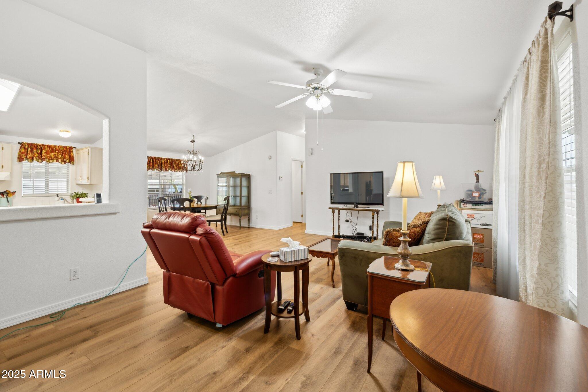 3901 East Pinnacle Peak Road, Unit 105 Phoenix, AZ 85050 - Photo 18 of 23 a living room with furniture a flat screen tv and kitchen view